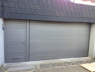 01 - Sekcijska garažna vrata z vodoravnim motivom, ob njih pa je osebni prehod - vrata ob vratih.