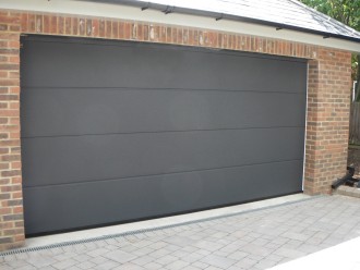 09 - Sekcijska garažna vrata v motivu široke črte in v antracit barvi.
