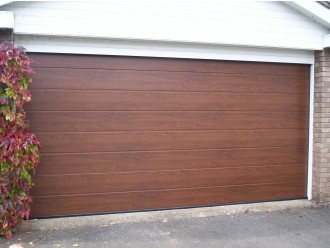 17 - Sekcijska vrata v motivu vodoravnih širokih črt in v barvi imitacije lesa.
